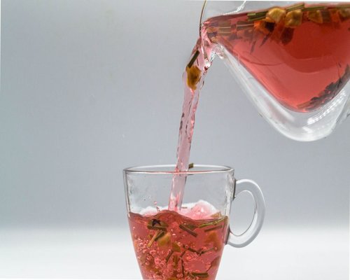 Pouring hot water into a cup with herbs